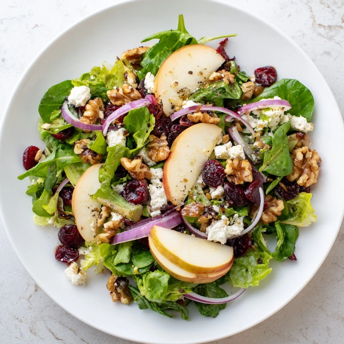 Vibrant Seasonal Cranberry and Walnut Celebration Salad with bright cranberries, toasted walnuts, and orange dressing.