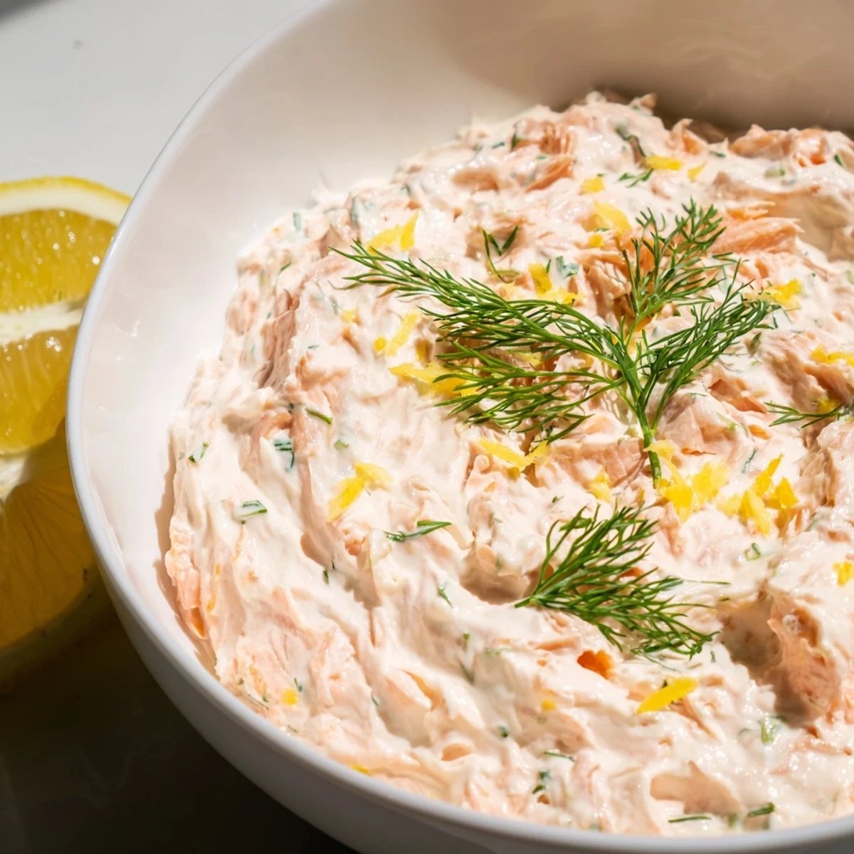 Smoked salmon dip served with crunchy bagel chips and cucumber slices, perfect for an elegant appetizer spread.