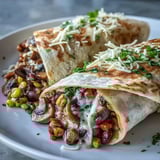 A close-up shows a sliced Veggie Burrito revealing a hearty filling of sautéed mushrooms, black beans, sweet corn, and melted cheese.