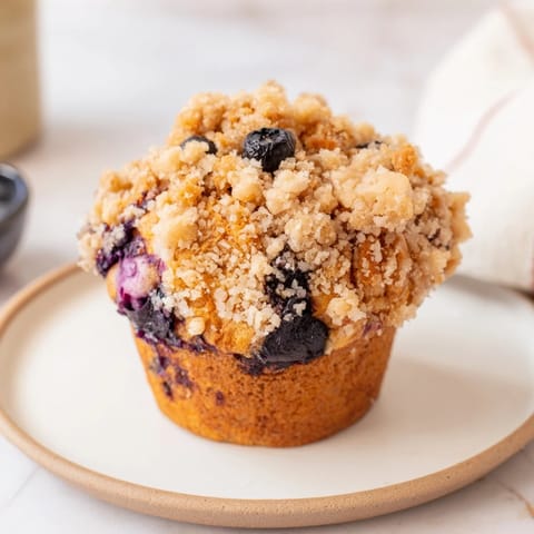 Warm, bakery-fresh blueberry muffins with streusel topping have a delightful aroma and texture.