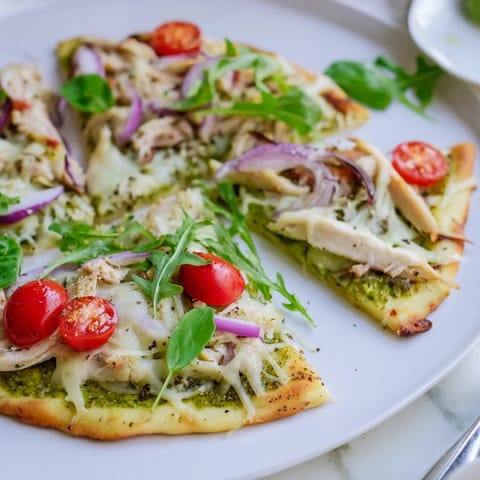 Savor the aroma of a freshly baked Pesto Chicken Flatbread, loaded with flavorful pesto and juicy chicken.