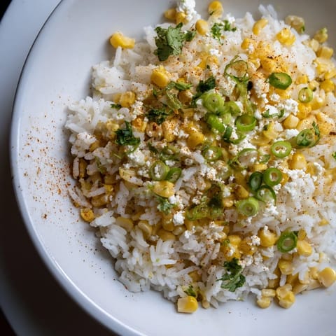 A colorful bowl of Mexican Street Corn Rice, featuring charred corn and zesty lime, perfect side dish.
