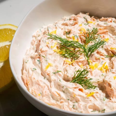 Smoked salmon dip served with crunchy bagel chips and cucumber slices, perfect for an elegant appetizer spread.