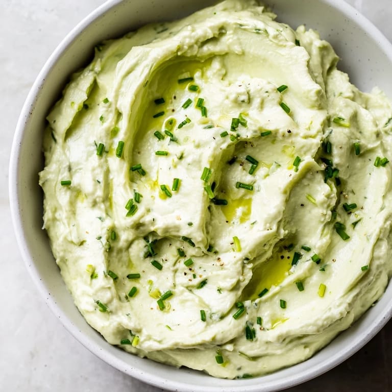 Smooth avocado cottage cheese dip, perfect for spreading or dipping, seasoned with chives and lemon.